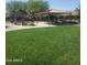 Community playground with a covered picnic area and lush green grass at 25945 W Runion Dr, Buckeye, AZ 85396