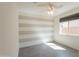 The bedroom features modern gray striped accent wall and window with shades at 2680 E Daniel Dr, Gilbert, AZ 85298