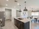 Modern kitchen featuring a dark island with granite countertop, stainless steel appliances, and views of the breakfast area at 2680 E Daniel Dr, Gilbert, AZ 85298
