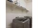 Modern laundry room featuring front-load washer and dryer units and open shelving at 2680 E Daniel Dr, Gilbert, AZ 85298