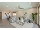 Open-concept living room featuring neutral tones, modern decor, tile flooring, and seamless transition to the dining area at 2680 E Daniel Dr, Gilbert, AZ 85298