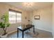 Office space with large window, chandelier, and a dark wood desk over a neutral rug at 2680 E Daniel Dr, Gilbert, AZ 85298