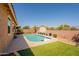 Backyard featuring a pool with a basketball hoop, surrounded by artificial turf and potted plants at 2680 E Daniel Dr, Gilbert, AZ 85298