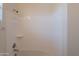 Clean bathroom shower features a white tub, shower head, and storage shelves, providing a functional space at 2680 E Daniel Dr, Gilbert, AZ 85298