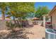 Landscaped backyard with patio seating, mature trees, and low-maintenance desert landscaping at 2896 W Hayden Peak Dr, San Tan Valley, AZ 85144