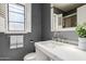 Bathroom featuring gray walls, white sink, modern faucet, shuttered window, and decorative accents at 2941 N 19Th Ave # 95, Phoenix, AZ 85015