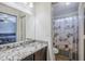 Bathroom featuring a granite vanity, mirror and a shower-tub combo with shell-themed shower curtain at 3351 W Via Del Sol Dr, Phoenix, AZ 85027