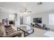 Living room with tiled flooring, ceiling fan, adjacent kitchen and large TV at 3351 W Via Del Sol Dr, Phoenix, AZ 85027