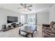 Bright living room with ceiling fan, tile floors, sliding door to backyard and a large TV at 3351 W Via Del Sol Dr, Phoenix, AZ 85027