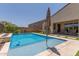 Inviting swimming pool featuring an umbrella, stone coping, artificial turf, and outdoor seating area at 34009 N 29Th Dr, Phoenix, AZ 85085
