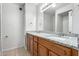Bathroom featuring granite countertops, dual sinks, and wood cabinets with a tile backsplash at 3811 W Loma Ln, Phoenix, AZ 85051