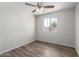 Bedroom featuring a ceiling fan, light and neutral paint, wood-look flooring, and window at 3811 W Loma Ln, Phoenix, AZ 85051