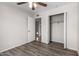 Bedroom with wood-look flooring, standard closet and open doorway to the bathroom at 3811 W Loma Ln, Phoenix, AZ 85051