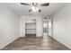 Bedroom with ceiling fan, closet, wood-look flooring, and bright white walls at 3811 W Loma Ln, Phoenix, AZ 85051