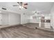 Open-concept living room with laminate floors, ceiling fan and seamless transition to the kitchen and backyard at 3811 W Loma Ln, Phoenix, AZ 85051