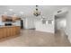 Open-concept living space with tile floors, wood kitchen bar, and connecting rooms with ceiling fans at 3811 W Loma Ln, Phoenix, AZ 85051
