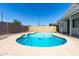 Backyard pool with concrete border surrounded by brick privacy fence and greenery at 3811 W Loma Ln, Phoenix, AZ 85051