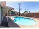 Backyard pool with stone border surrounded by privacy fence and mature landscaping at 3811 W Loma Ln, Phoenix, AZ 85051