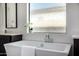 Soaking tub with modern fixtures and a frosted window in a bathroom at 3822 E Canyon Pl, Chandler, AZ 85249