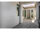 Covered entryway with stone pavers leading to a modern front door surrounded by sidelight windows at 3822 E Canyon Pl, Chandler, AZ 85249