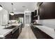 Elegant kitchen featuring stainless steel appliances, dark cabinetry, and a sleek backsplash at 3822 E Canyon Pl, Chandler, AZ 85249