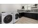Well-equipped laundry room features modern washer and dryer set, chic backsplash and tile flooring at 3822 E Canyon Pl, Chandler, AZ 85249