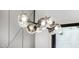 Close-up of a modern chandelier with glass orbs and dark metal fixture over a table in a dining area at 3822 E Canyon Pl, Chandler, AZ 85249