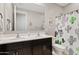 Neutral bathroom with double sinks, decorative wall art, and cactus shower curtain at 4091 W Suncup Dr, San Tan Valley, AZ 85144