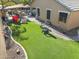 Well-manicured backyard with artificial turf, a dining area, and outdoor games for entertainment at 4111 S Dewdrop Ct, Gilbert, AZ 85297