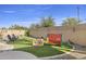 Spacious backyard featuring artificial turf, stone accents, patio seating, and outdoor games at 4111 S Dewdrop Ct, Gilbert, AZ 85297