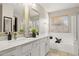 Elegant bathroom featuring double sinks, granite countertops, and a soaking tub at 4111 S Dewdrop Ct, Gilbert, AZ 85297