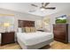 Bright main bedroom featuring a king bed, wood floors, ceiling fan, and TV at 4111 S Dewdrop Ct, Gilbert, AZ 85297