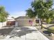 Exterior front view of home with a 2-car garage, landscaped yard and long driveway at 4111 S Dewdrop Ct, Gilbert, AZ 85297