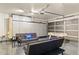Finished garage with gray epoxy flooring, storage cabinets, foosball table, and seating area with blue pillows at 4111 S Dewdrop Ct, Gilbert, AZ 85297