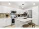 Well-lit kitchen with stainless steel appliances, granite countertops, island, and white cabinets at 4111 S Dewdrop Ct, Gilbert, AZ 85297