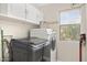 Well-equipped laundry room featuring modern washer and dryer units, upper cabinets, and natural light at 4111 S Dewdrop Ct, Gilbert, AZ 85297
