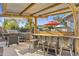 Covered outdoor bar with corrugated metal roofing, built-in counter, and seating for entertaining at 4111 S Dewdrop Ct, Gilbert, AZ 85297