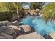 Backyard pool featuring rocks and lush landscaping creating a private and serene oasis at 4111 S Dewdrop Ct, Gilbert, AZ 85297