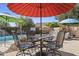 Inviting poolside patio with dining area, featuring decorative outdoor furniture under colorful umbrellas at 4111 S Dewdrop Ct, Gilbert, AZ 85297