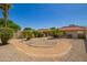 Expansive backyard featuring desert landscaping, including palm trees, with a patio and red tile roofs at 4216 E Sandia St, Phoenix, AZ 85044