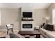 Modern living room with a fireplace, mounted TV, and a neutral color palette at 4216 E Sandia St, Phoenix, AZ 85044