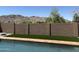 The backyard features a shimmering pool, artificial turf, and stone masonry wall at 4416 E Capistrano Ave, Phoenix, AZ 85044