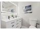 Modern bathroom with a double vanity, sleek black hardware, and a large, illuminated mirror at 4416 E Capistrano Ave, Phoenix, AZ 85044
