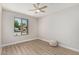 Bright bedroom with a ceiling fan, hardwood floors and a window overlooking the neighborhood at 4416 E Capistrano Ave, Phoenix, AZ 85044