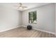 Bright bedroom with a ceiling fan, hardwood floors and a window overlooking a tree at 4416 E Capistrano Ave, Phoenix, AZ 85044