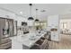 Modern kitchen with white cabinets, stainless steel appliances, and a large center island with marble countertops at 4416 E Capistrano Ave, Phoenix, AZ 85044