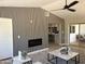 Cozy living room featuring linear fireplace, modern wood wall, open floor plan and ceiling fan at 4416 E Capistrano Ave, Phoenix, AZ 85044