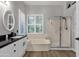 Well-lit bathroom featuring a large tub, shower, and sink with a view from the window at 4680 E Nightingale Ln, Gilbert, AZ 85298