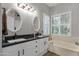 Bright bathroom featuring dual sinks, granite countertops, and a garden tub beneath a window at 4680 E Nightingale Ln, Gilbert, AZ 85298