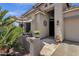 Close-up of a home's entrance with decorative wall art, potted plants, and an inviting shaded entryway at 4680 E Nightingale Ln, Gilbert, AZ 85298